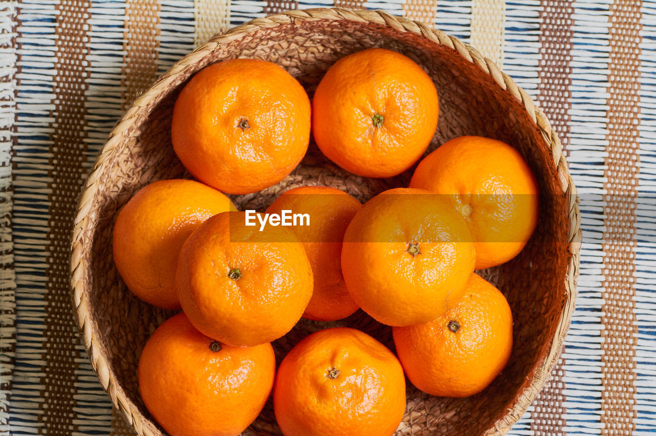 HIGH ANGLE VIEW OF ORANGE FRUITS IN BASKET ON TABLE