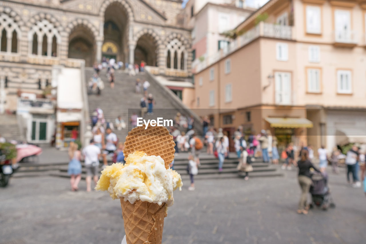 Ice cream cone against people in city
