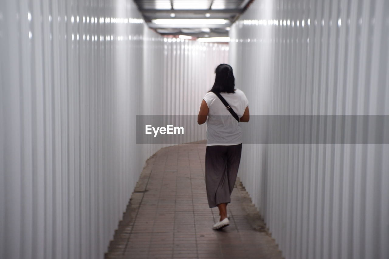 Rear view of woman walking in corridor