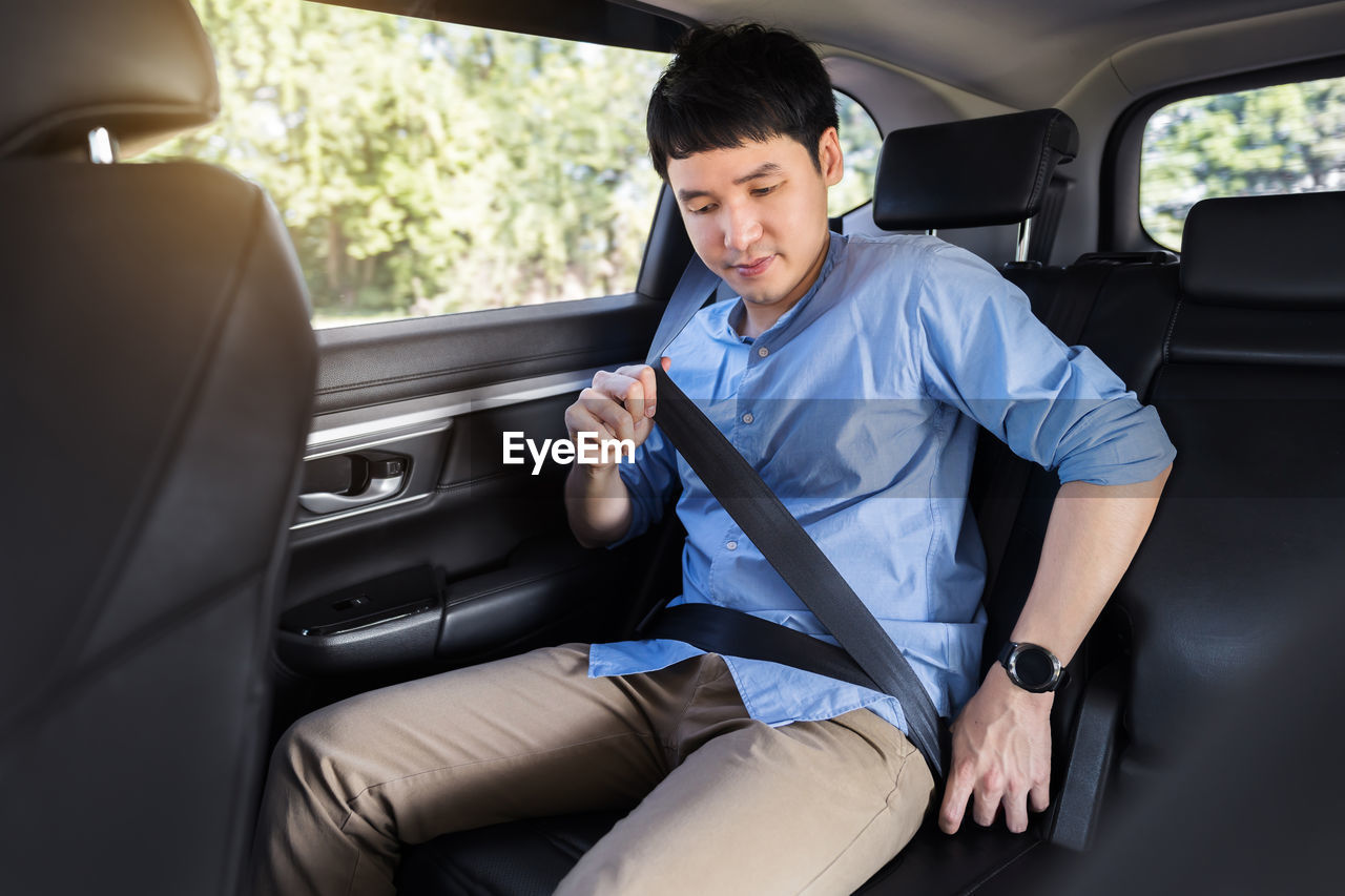 portrait of a young man driving in car