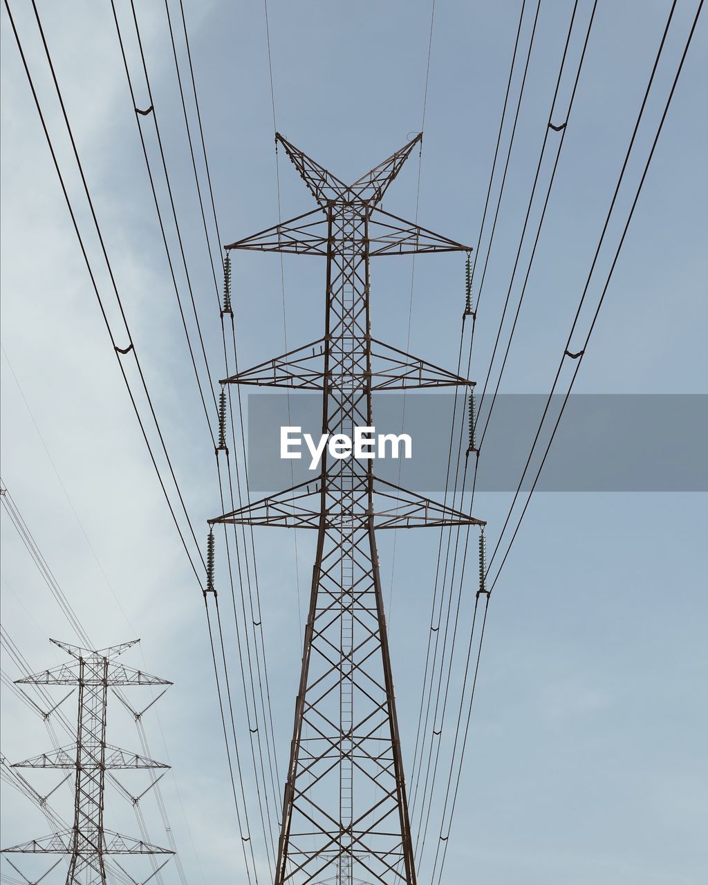 DIRECTLY BELOW SHOT OF ELECTRICITY PYLON AGAINST SKY