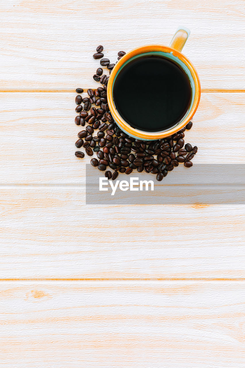 HIGH ANGLE VIEW OF COFFEE CUP ON WOODEN TABLE