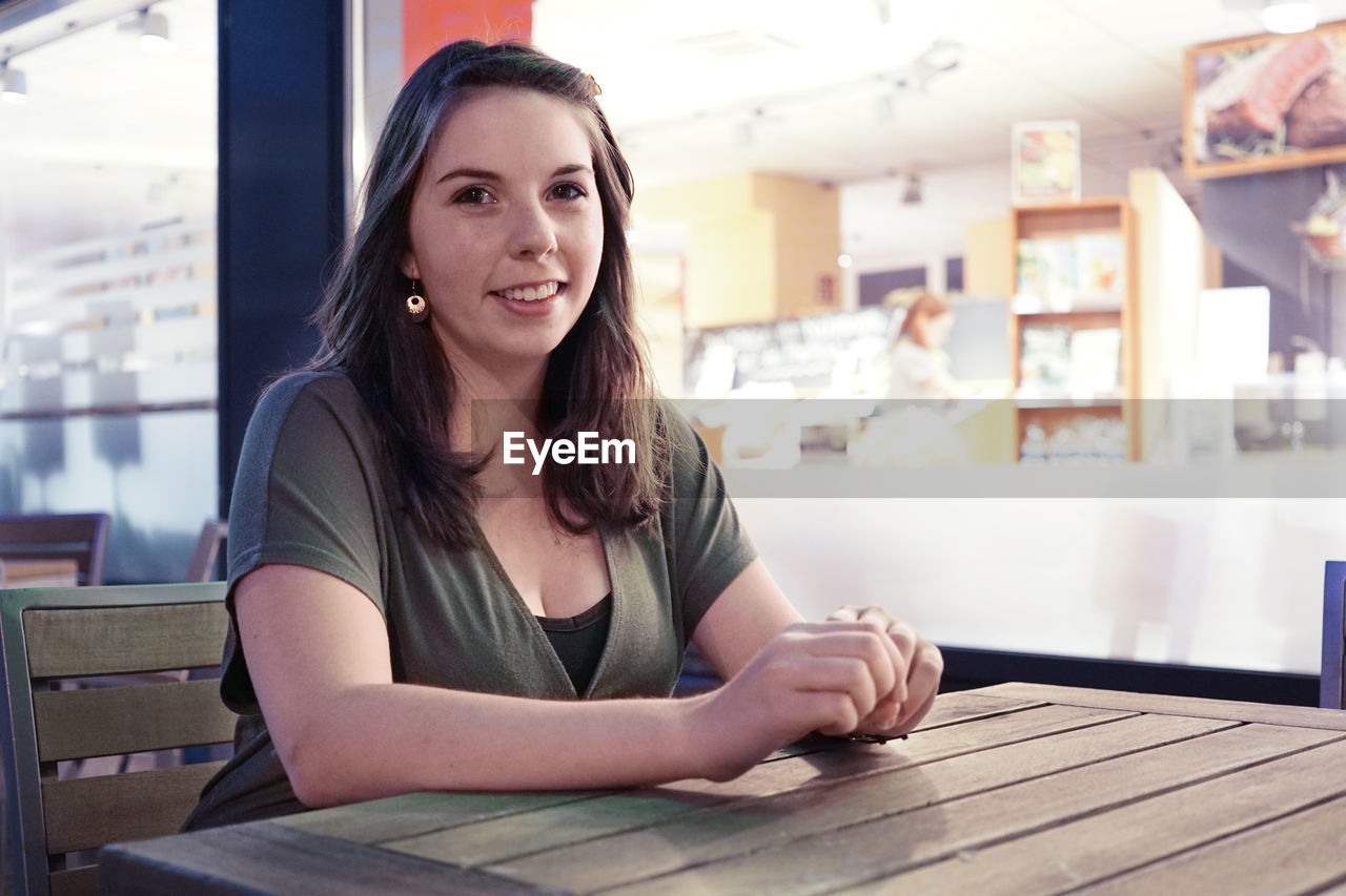 Portrait of smiling woman sitting at cafe