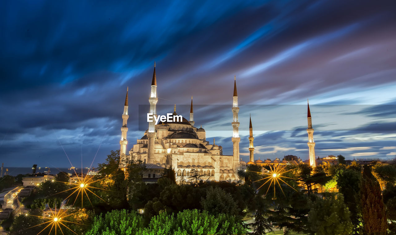 Low angle view of blue mosque against cloudy sky at dusk