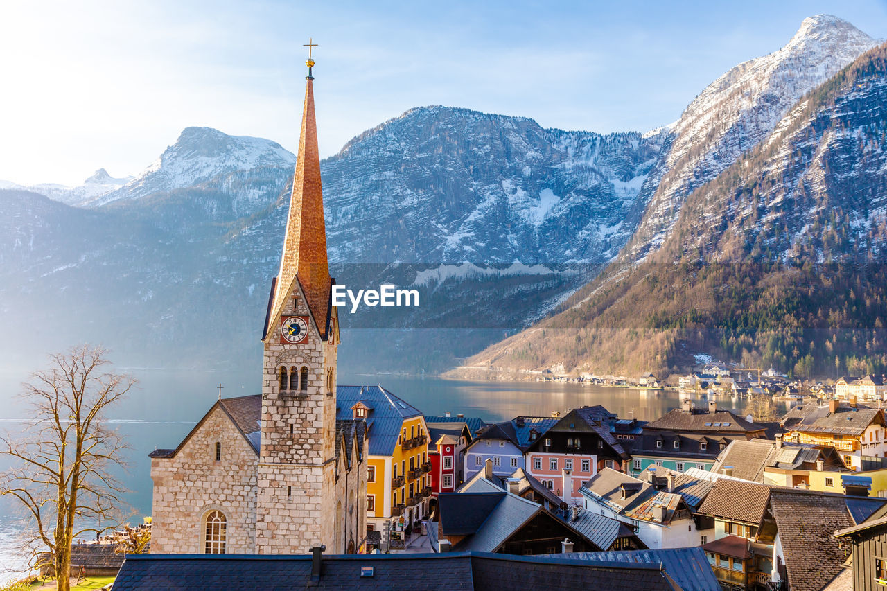 View of beautiful hallstatt famous church during morning sunrise in early spring with mountain range