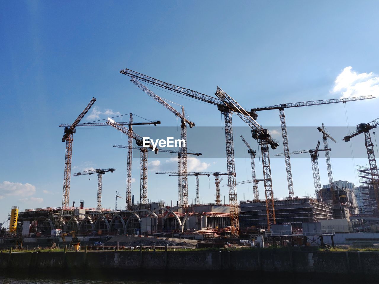 Construction cranes against sky