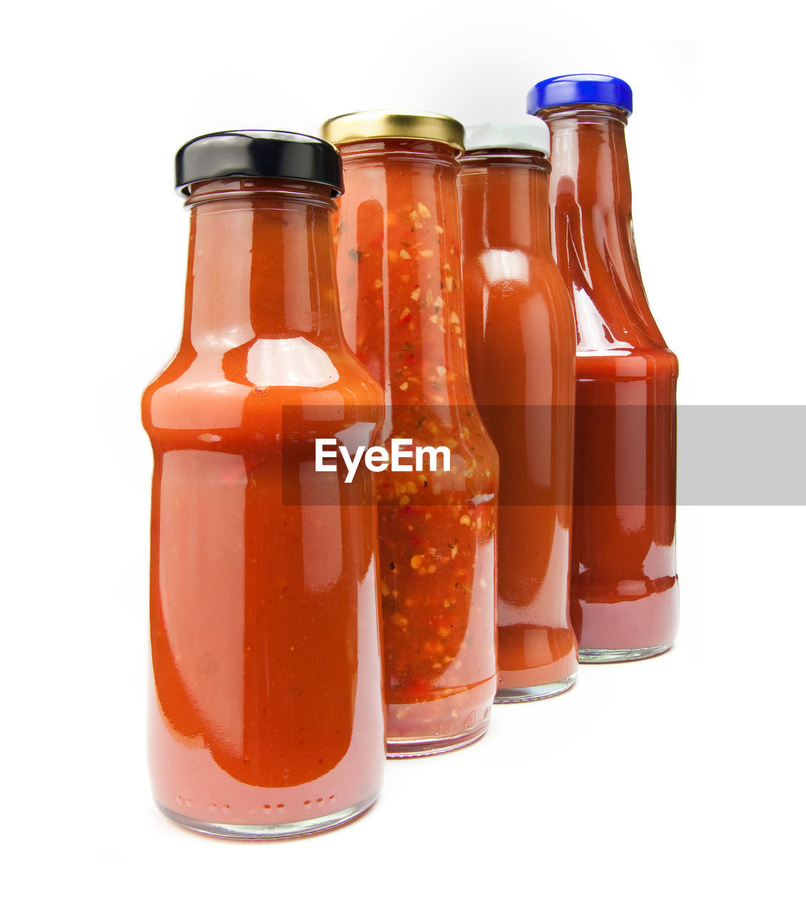 Close-up of sauces in bottles against white background