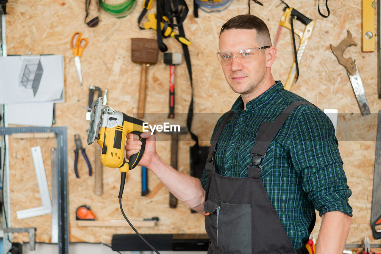 portrait of young man standing in workshop