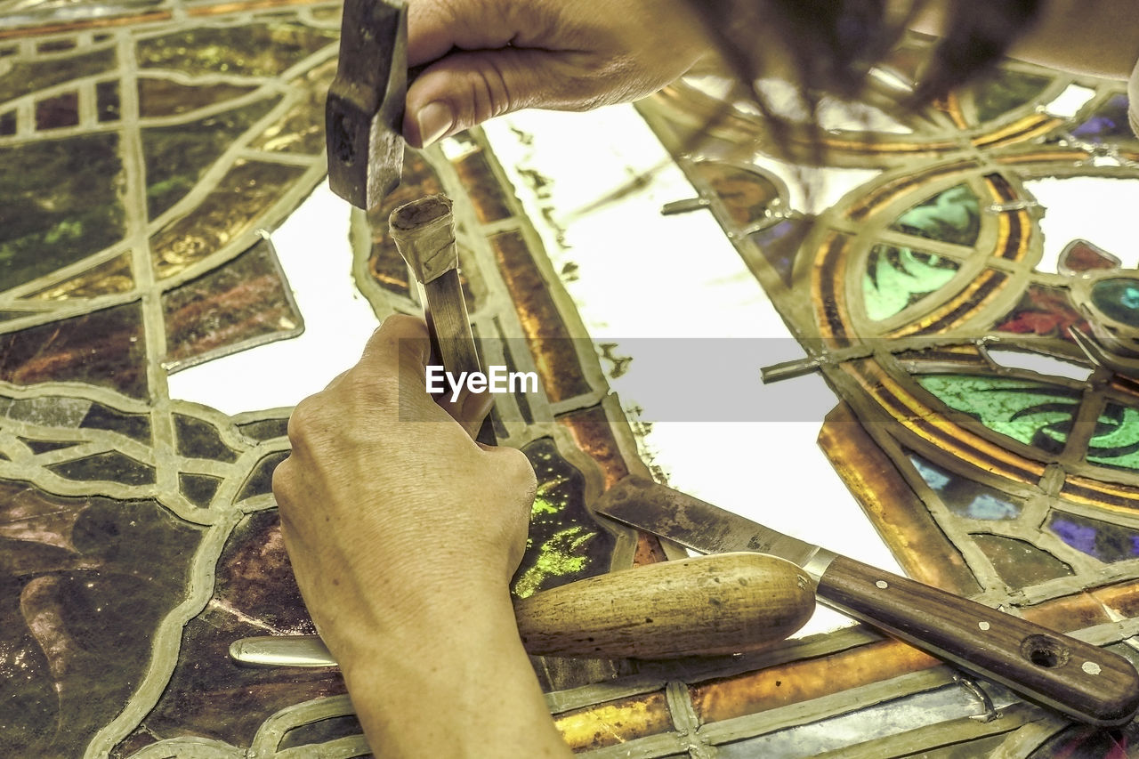 Cropped hands of man craving on table