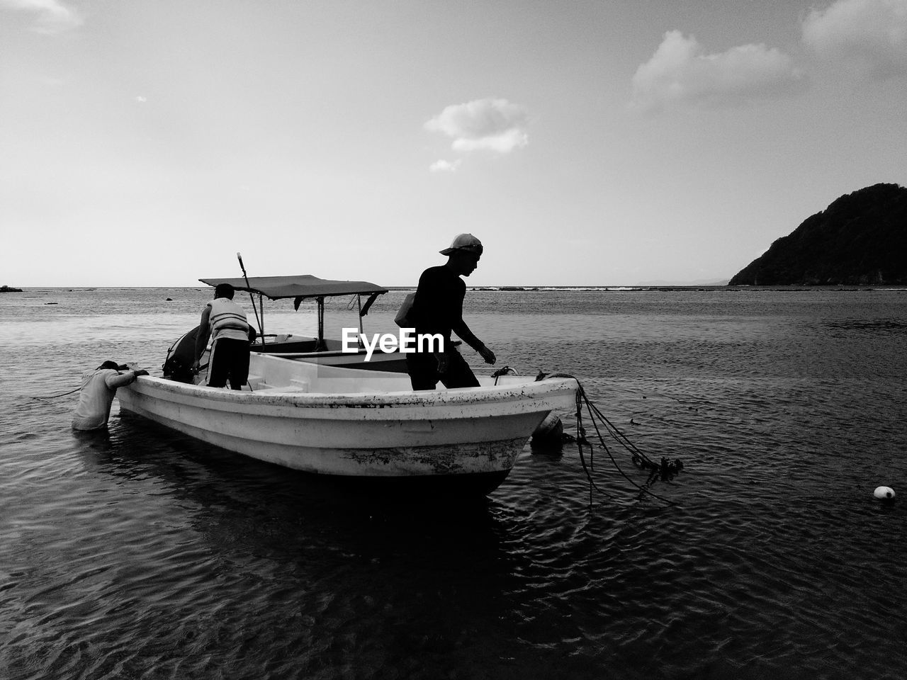 MAN FISHING IN SEA AGAINST SKY