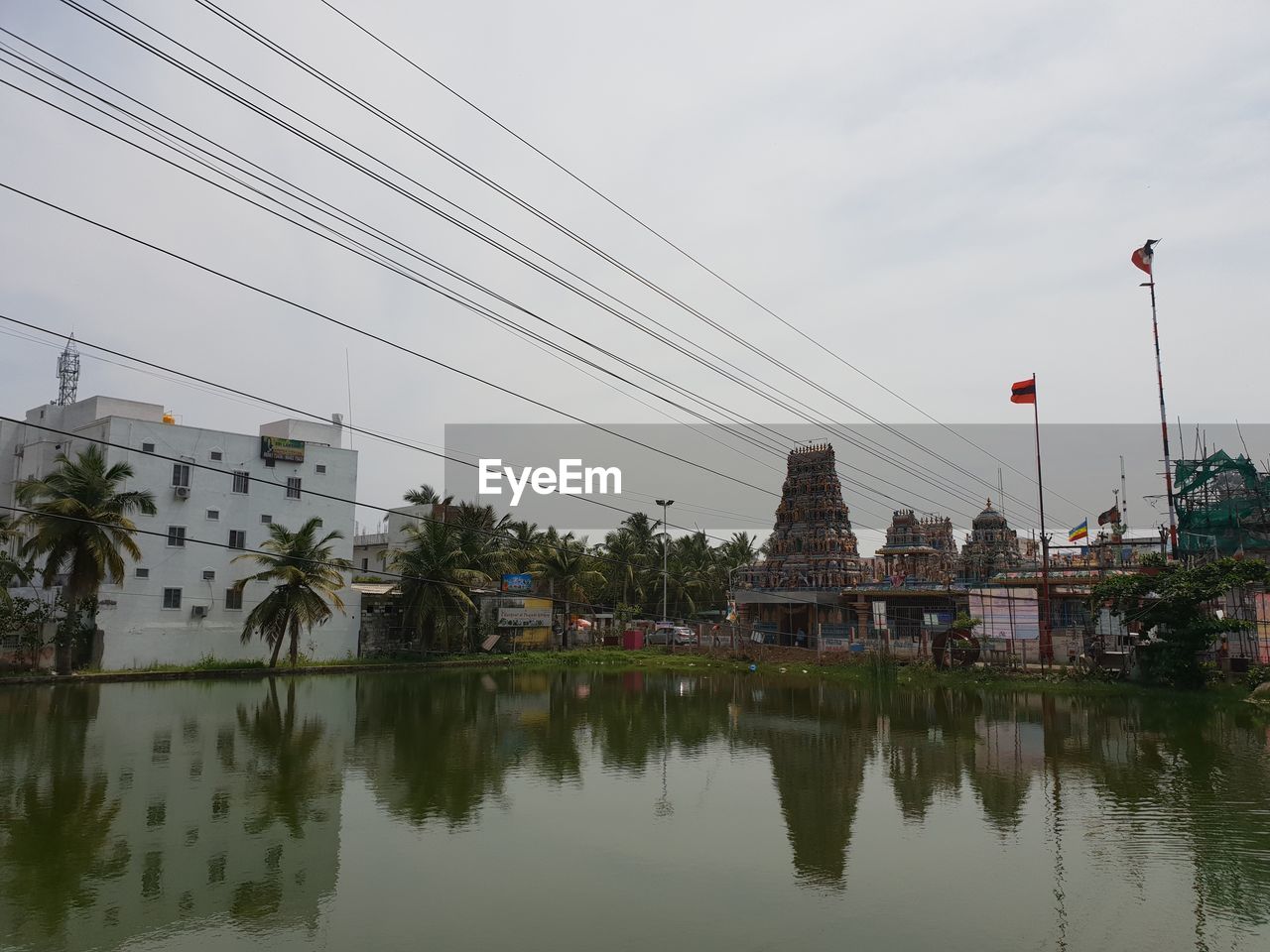 Reflection of trees and buildings in lake against sky