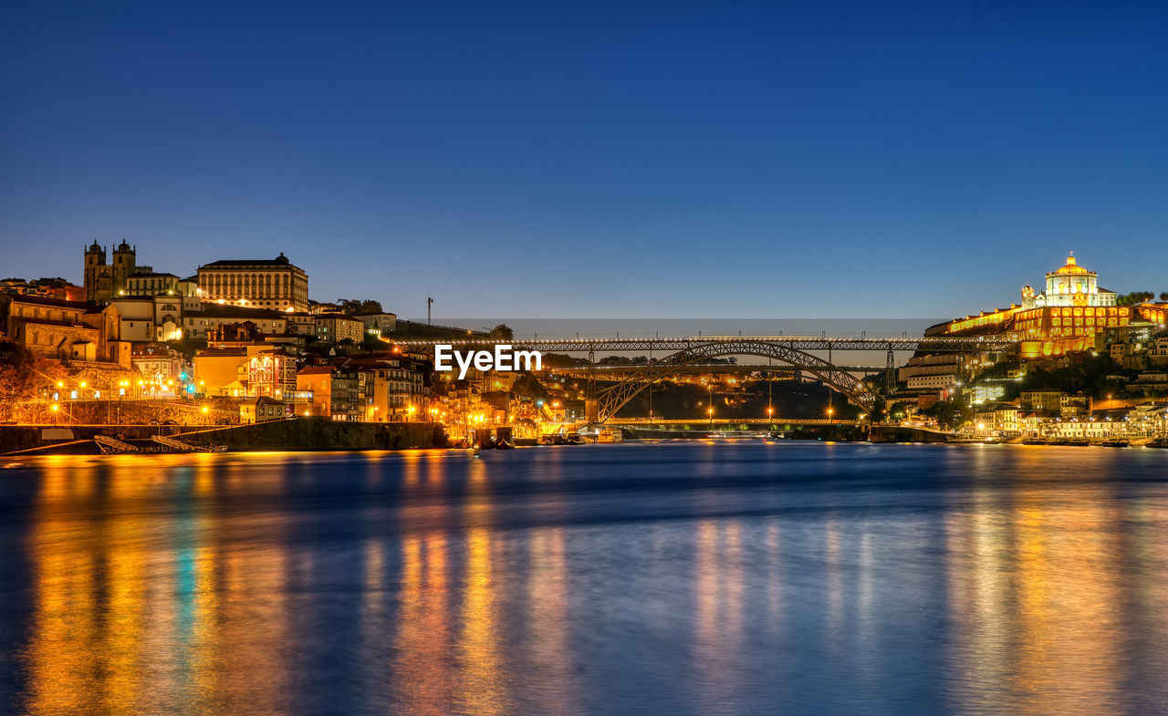 View of porto along the river douro at dawn with the famous iron bridge in the back