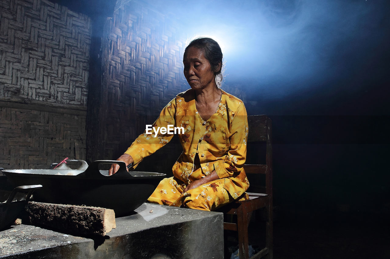 Woman preparing food in darkroom