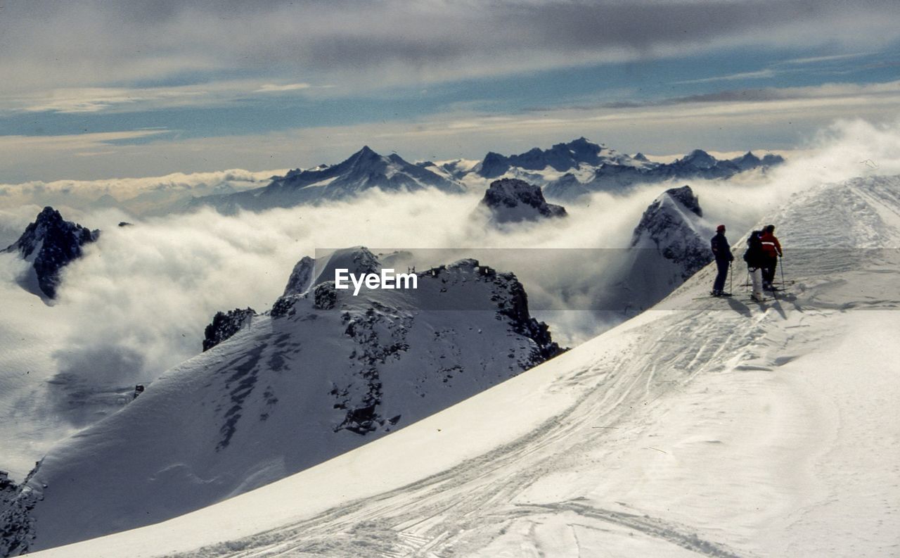 Rear view of mountaineers standing on snowcapped mountains