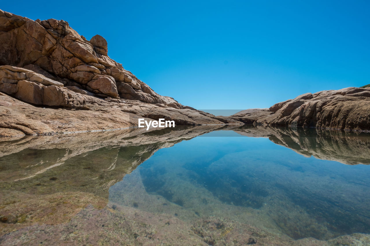 Scenic view of rock formations against blue sky