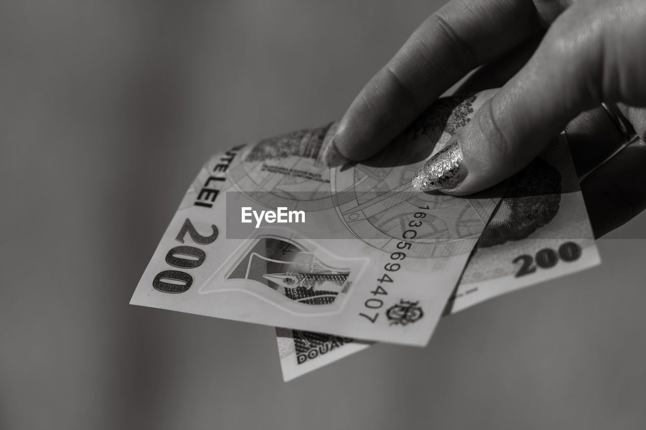 cropped hand of person holding paper currency