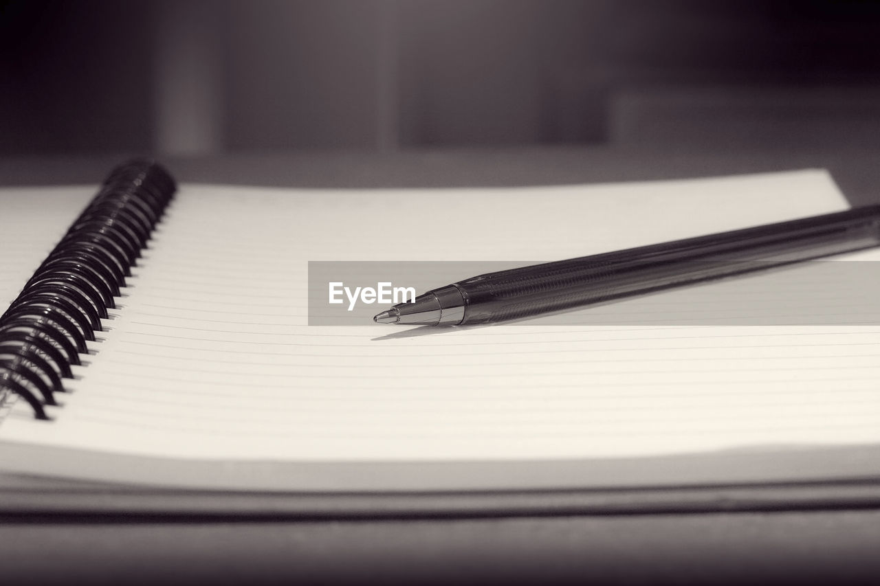 Close-up of pen with diary on table