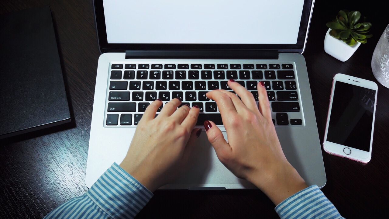 MIDSECTION OF WOMAN USING LAPTOP