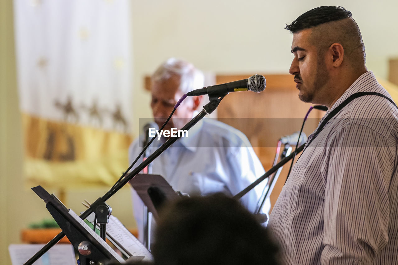 Men singing through microphones