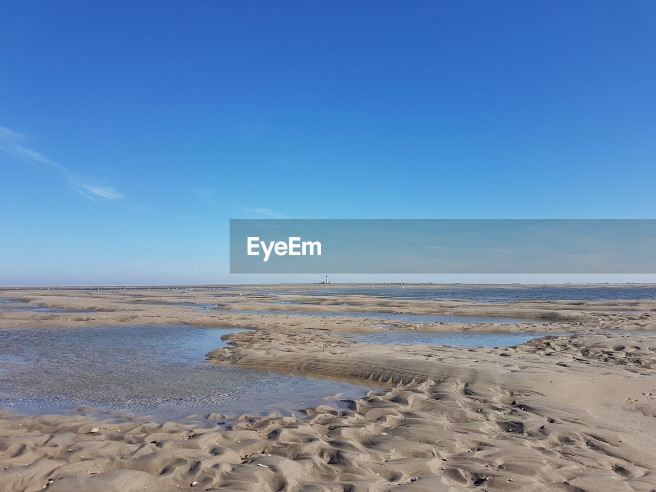 Scenic view of beach against blue sky