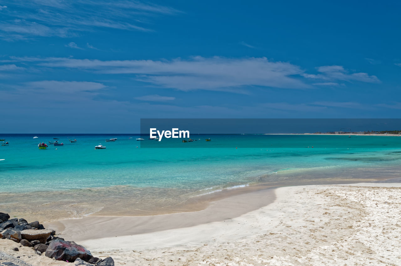 Scenic view of beach against blue sky