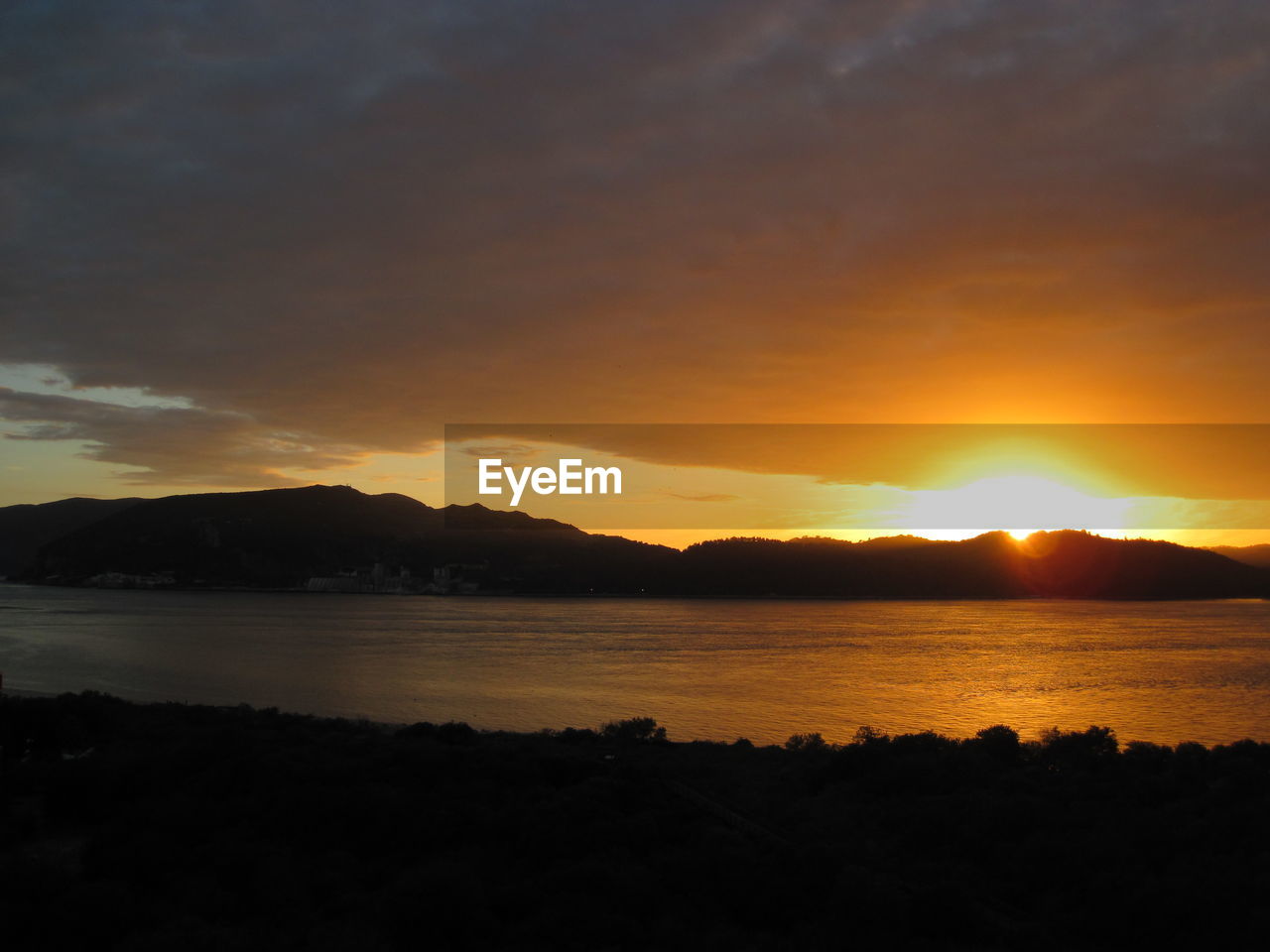 SCENIC VIEW OF LAKE AGAINST SKY AT SUNSET