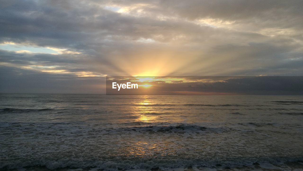 SCENIC VIEW OF BEACH AGAINST DRAMATIC SKY