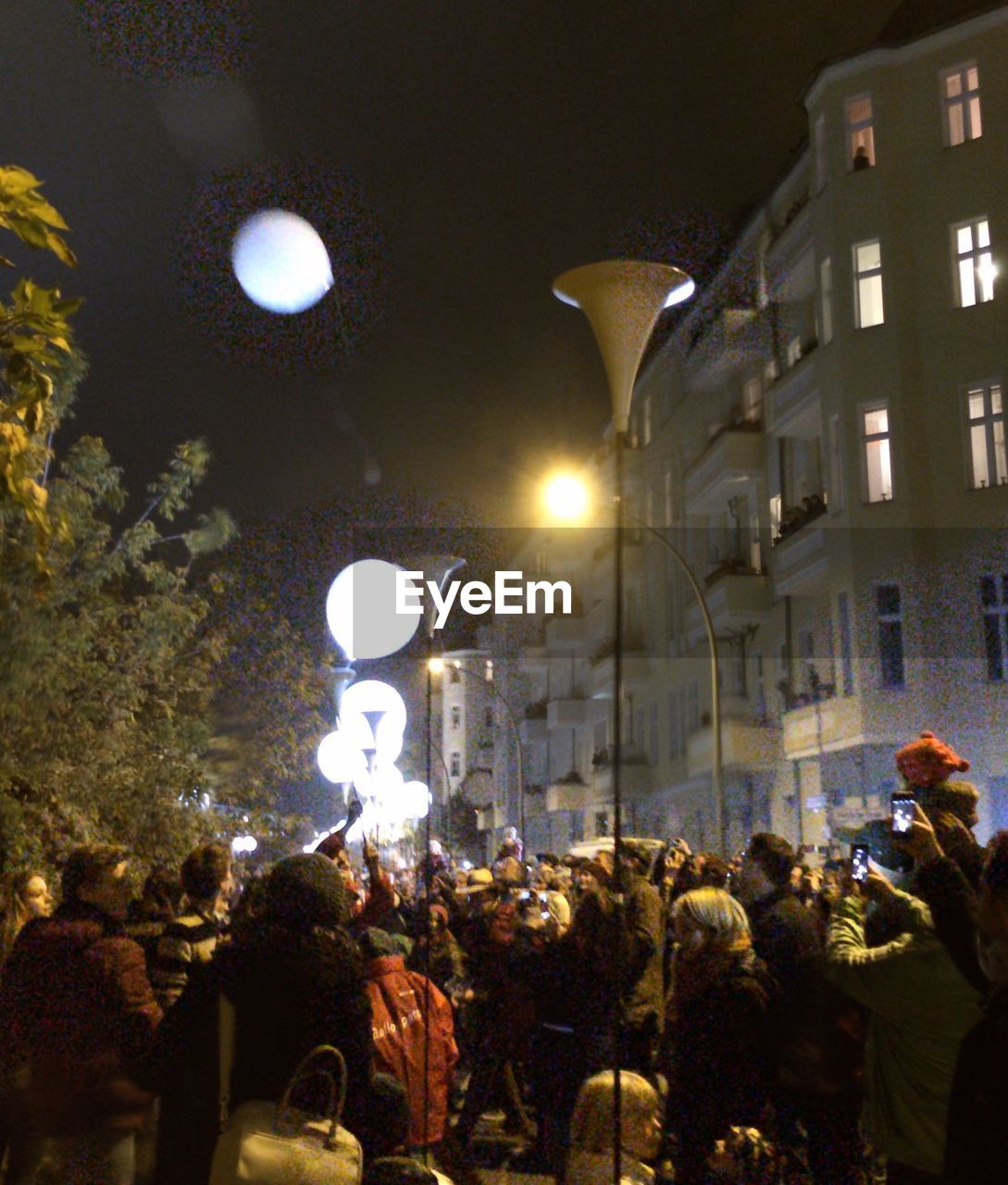 PEOPLE IN ILLUMINATED CITY AT NIGHT