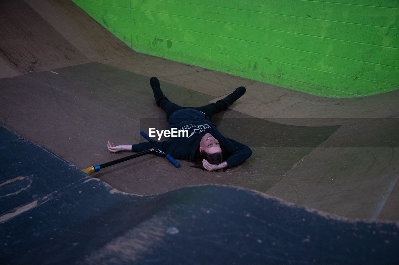 HIGH ANGLE PORTRAIT OF MAN LYING DOWN ON WALL