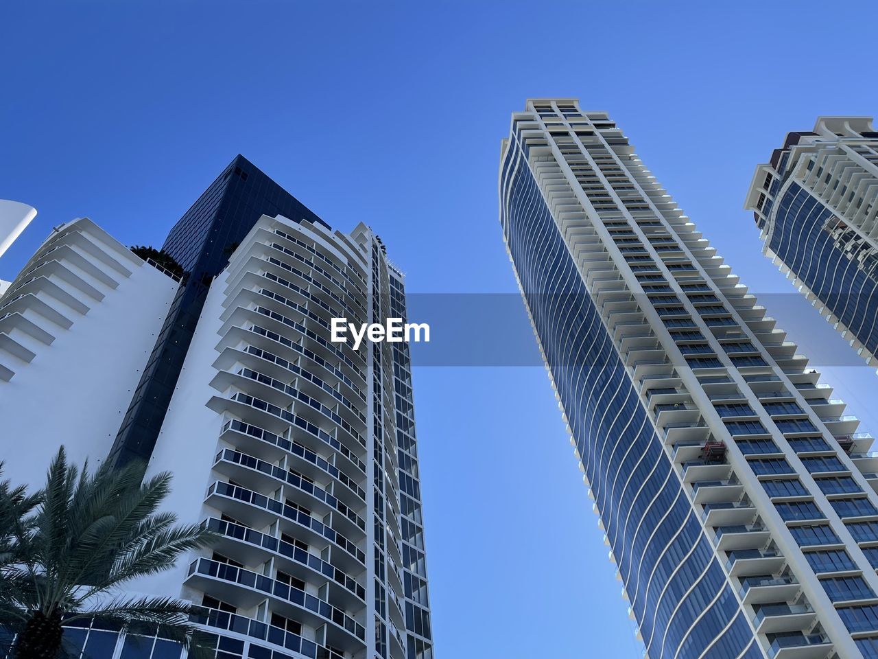 low angle view of modern buildings against clear blue sky