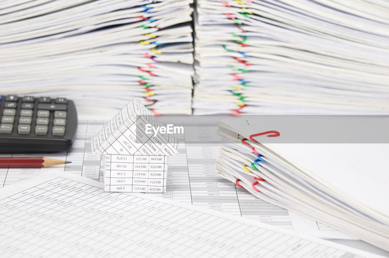 Close-up of model house and calculator on financial documents