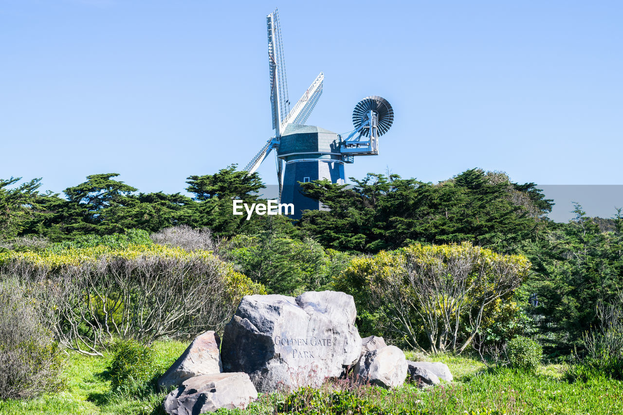 TRADITIONAL WINDMILL ON FIELD AGAINST SKY