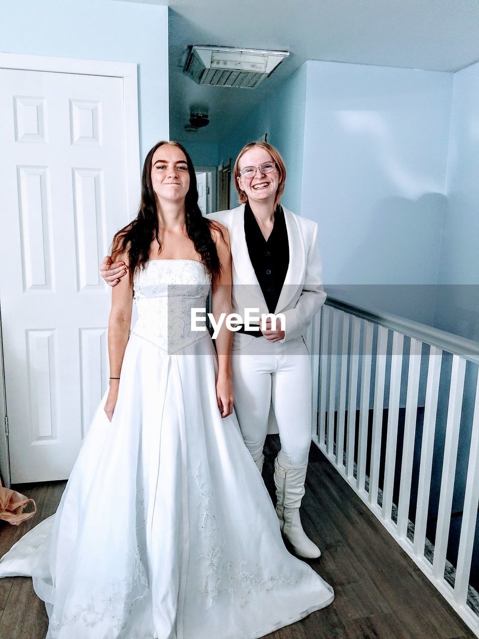 Portrait of bride with female friend at bridal shop