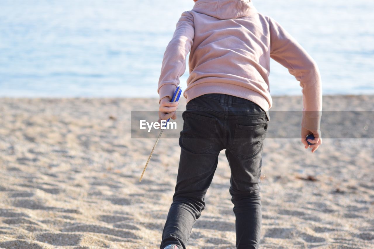 Rear view of boy walking on beach