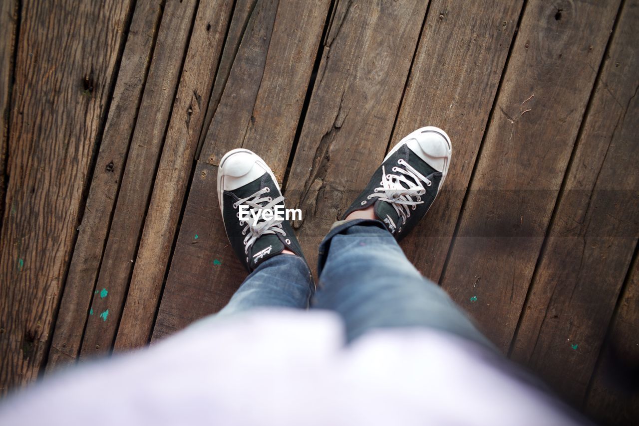 LOW SECTION OF WOMAN STANDING ON FLOOR