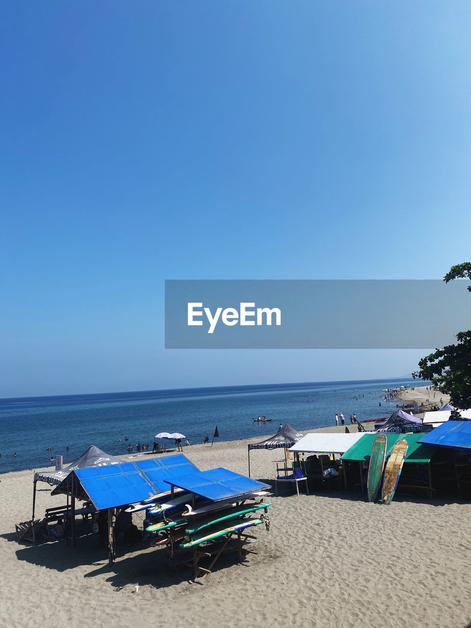 beach, sea, water, land, sky, ocean, sand, nature, horizon over water, body of water, coast, horizon, shore, blue, scenics - nature, tranquility, beauty in nature, bay, chair, holiday, vacation, clear sky, trip, tranquil scene, travel destinations, sunlight, day, sunny, summer, travel, no people, copy space, lounge chair, idyllic, outdoors, relaxation, tropical climate, tourism, seat, coastline, nautical vessel, parasol, transportation, umbrella, beach umbrella, hut, non-urban scene, seascape, tree, mode of transportation