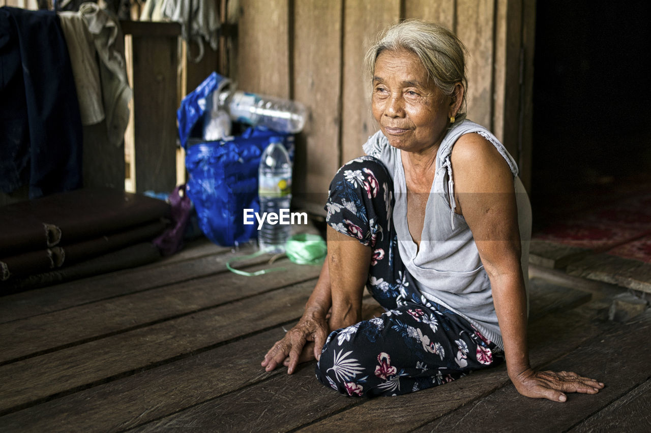 A single indigenous woman sitting and smiling