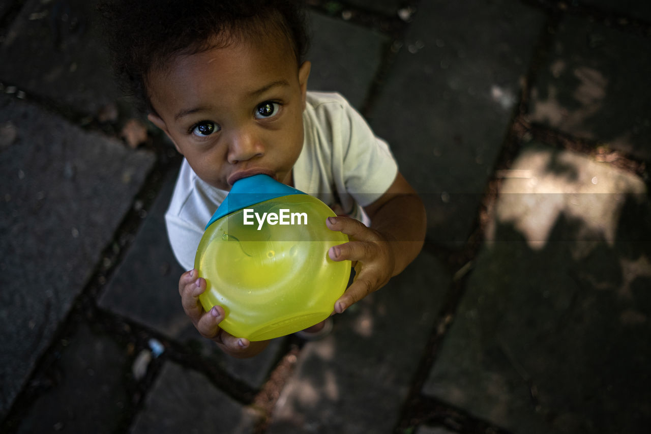 Toddler boy stays hydrated on summer day 