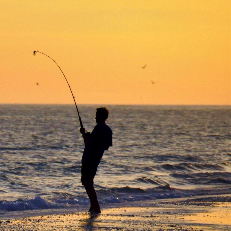 SILHOUETTE OF PEOPLE FISHING AT BEACH
