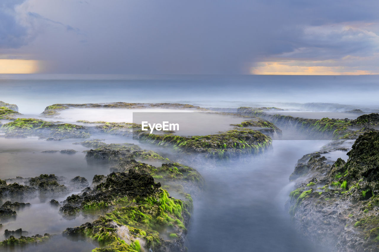 Scenic view of waterfall against sky