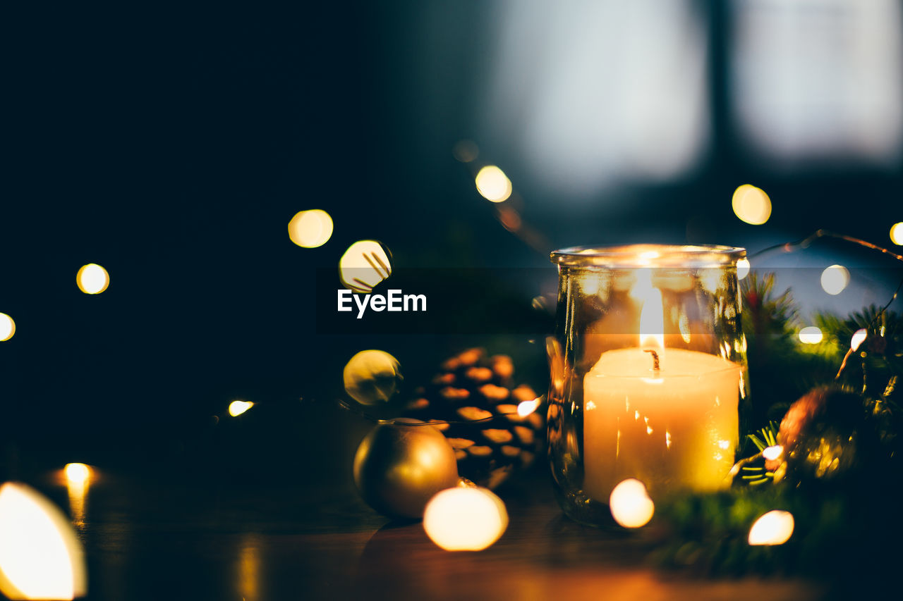 Close-up of illuminated candles on table