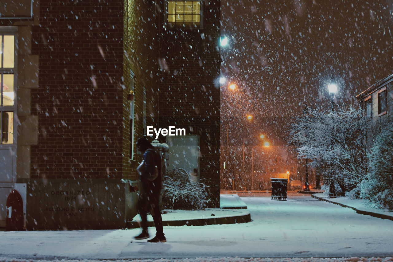 Full length of illuminated street during winter at night