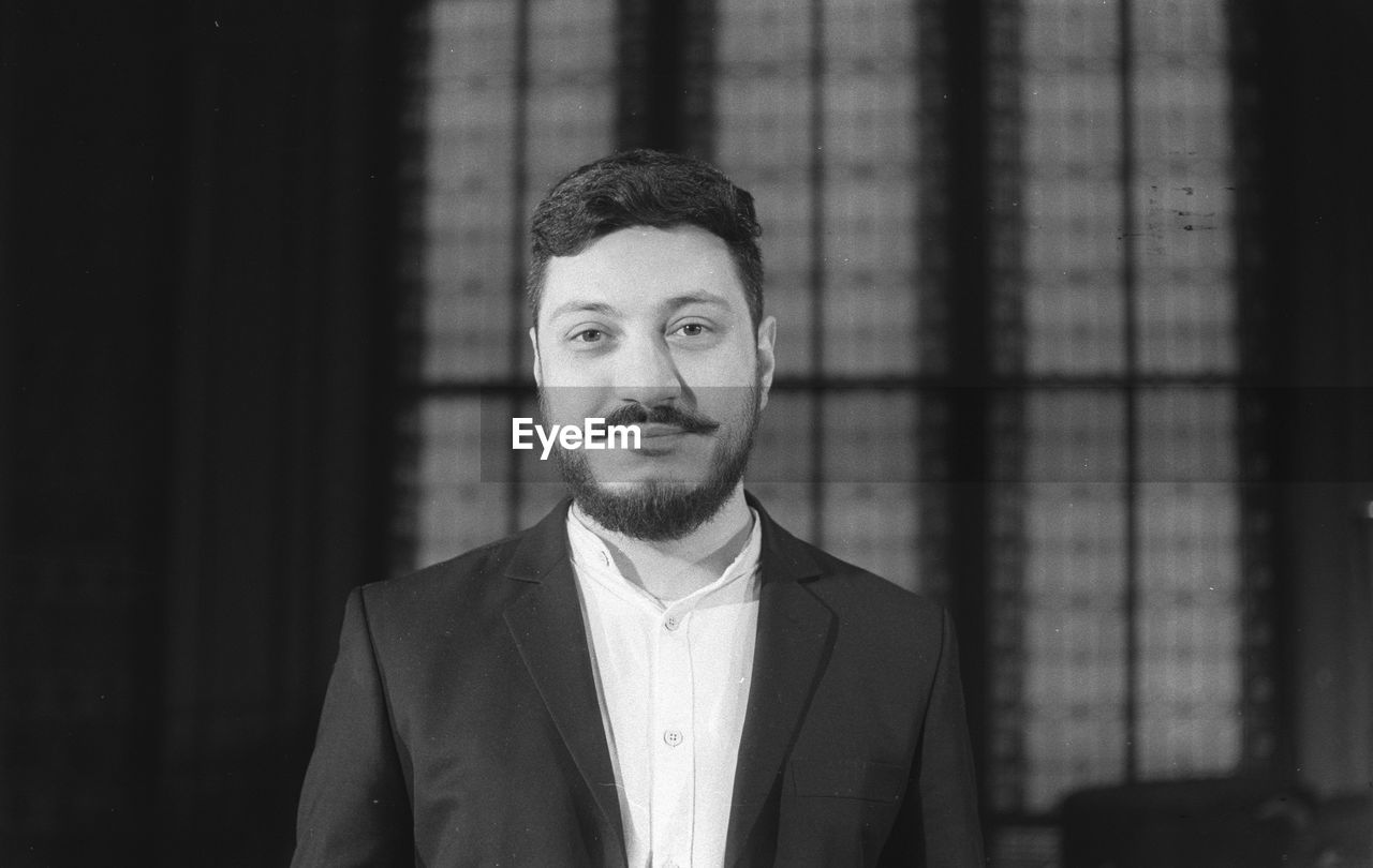 Portrait of bearded man standing indoors