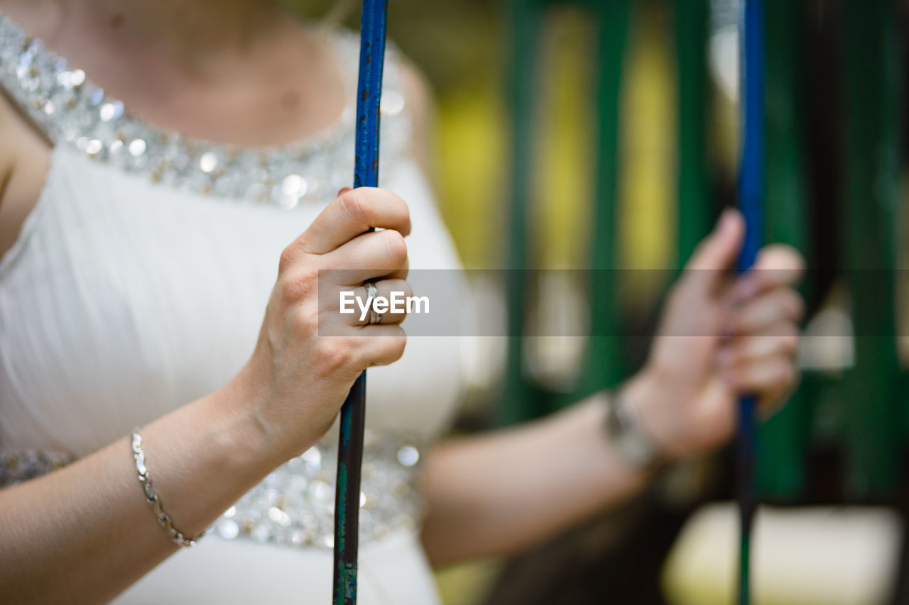 Midsection of woman holding rods