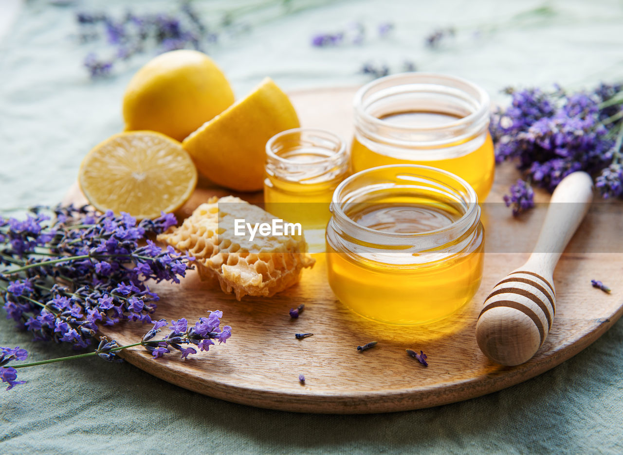 Glass of honey, honeycomb and lavender flowers