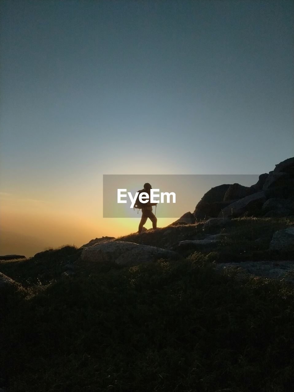 Hiker walking on mountain during sunset