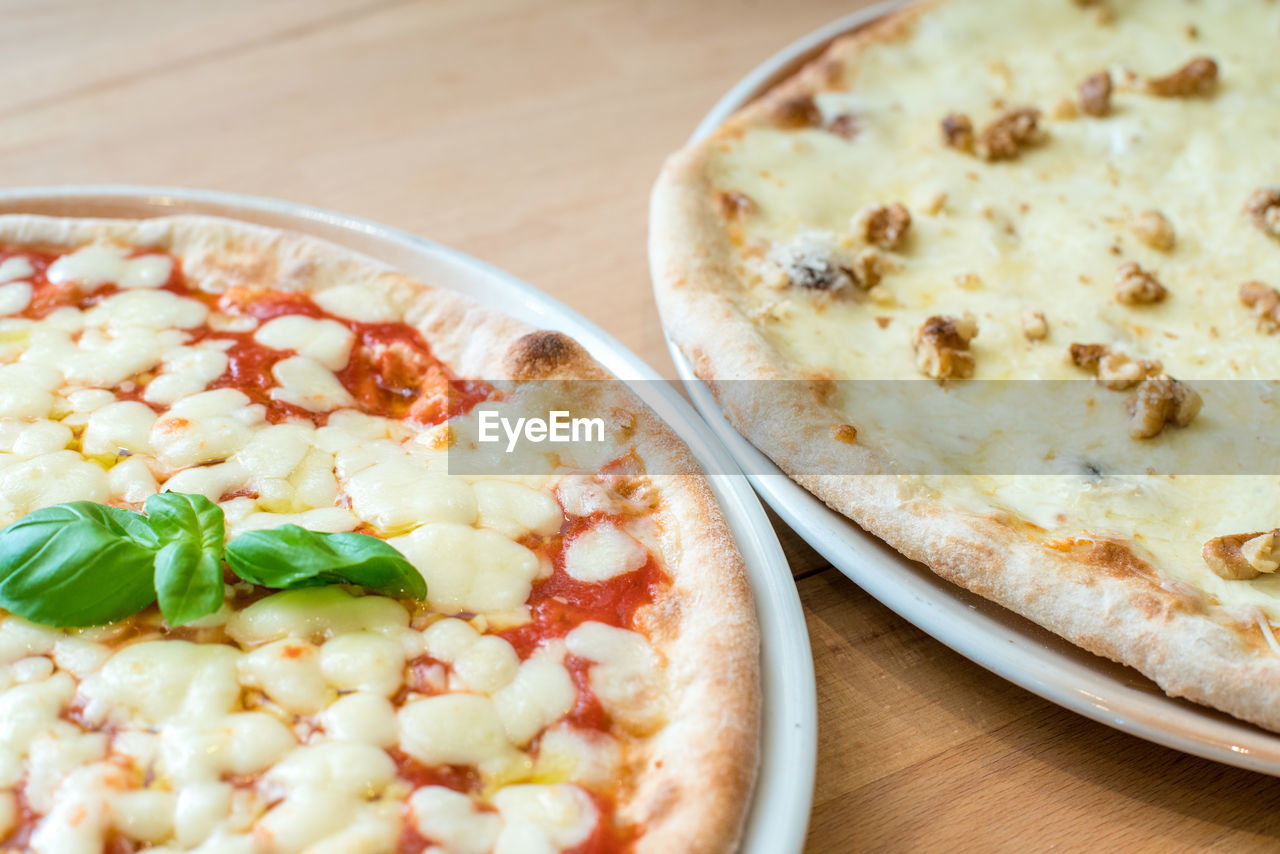 Traditional italian pizza margherita and gorgonzola cheese and walnuts. selective focus