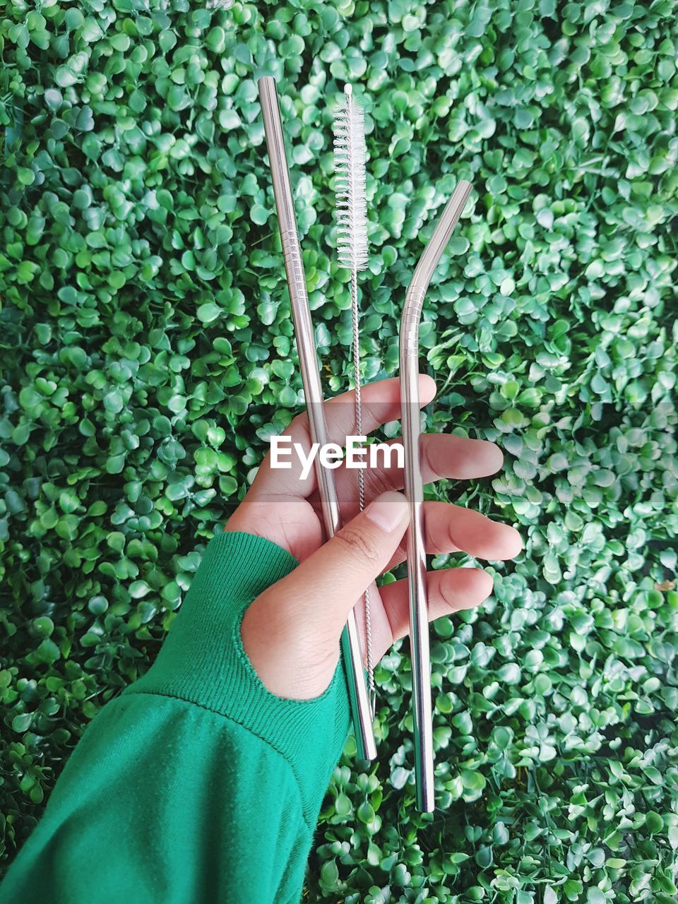 High angle view of woman holding stainless steel equipments against plants