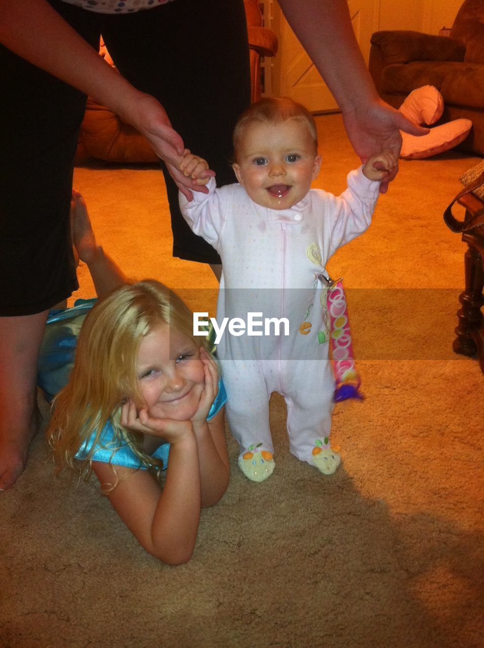 Toddler standing up with big sister