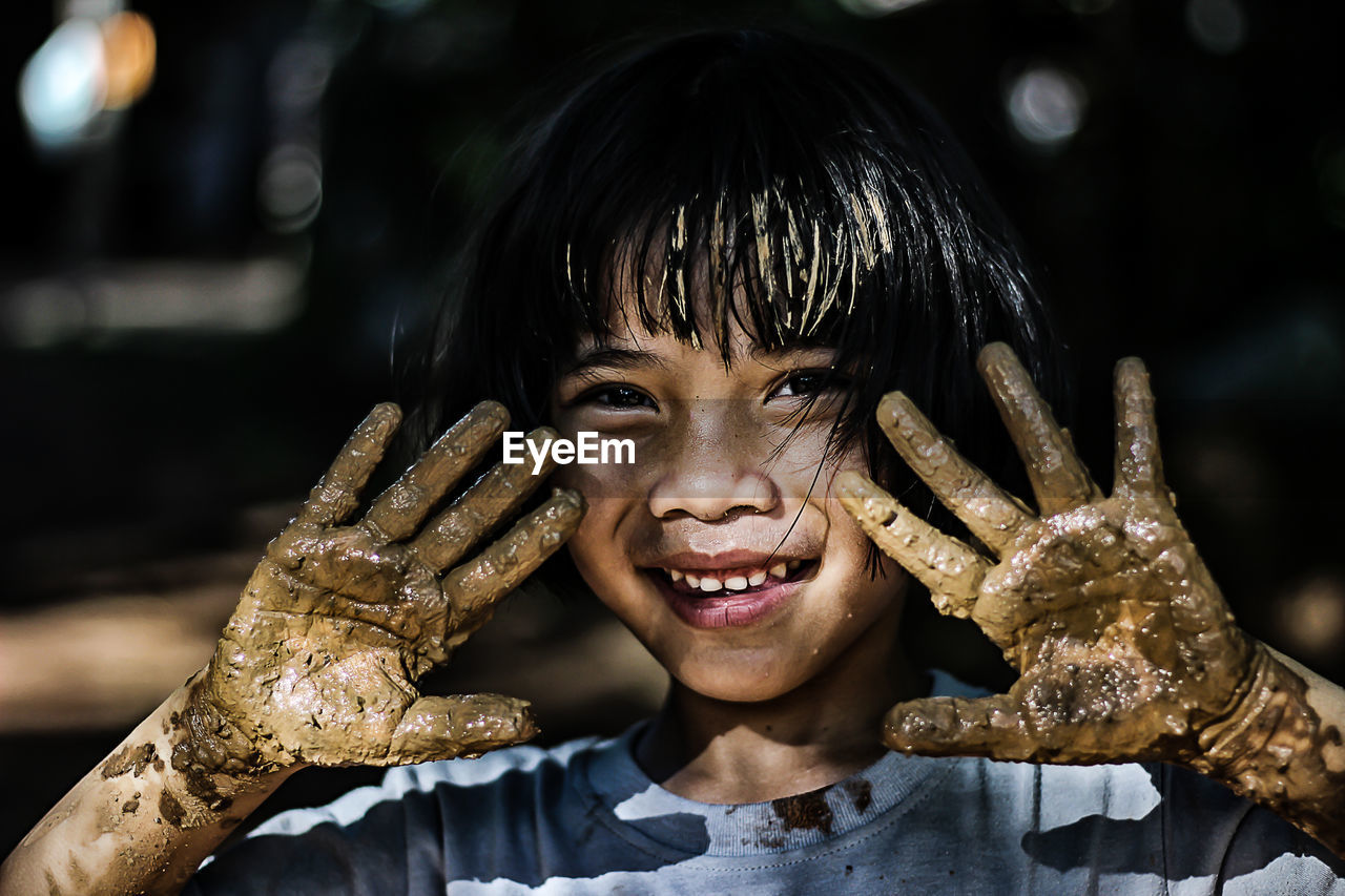 Close-up portrait of girl covered in mud